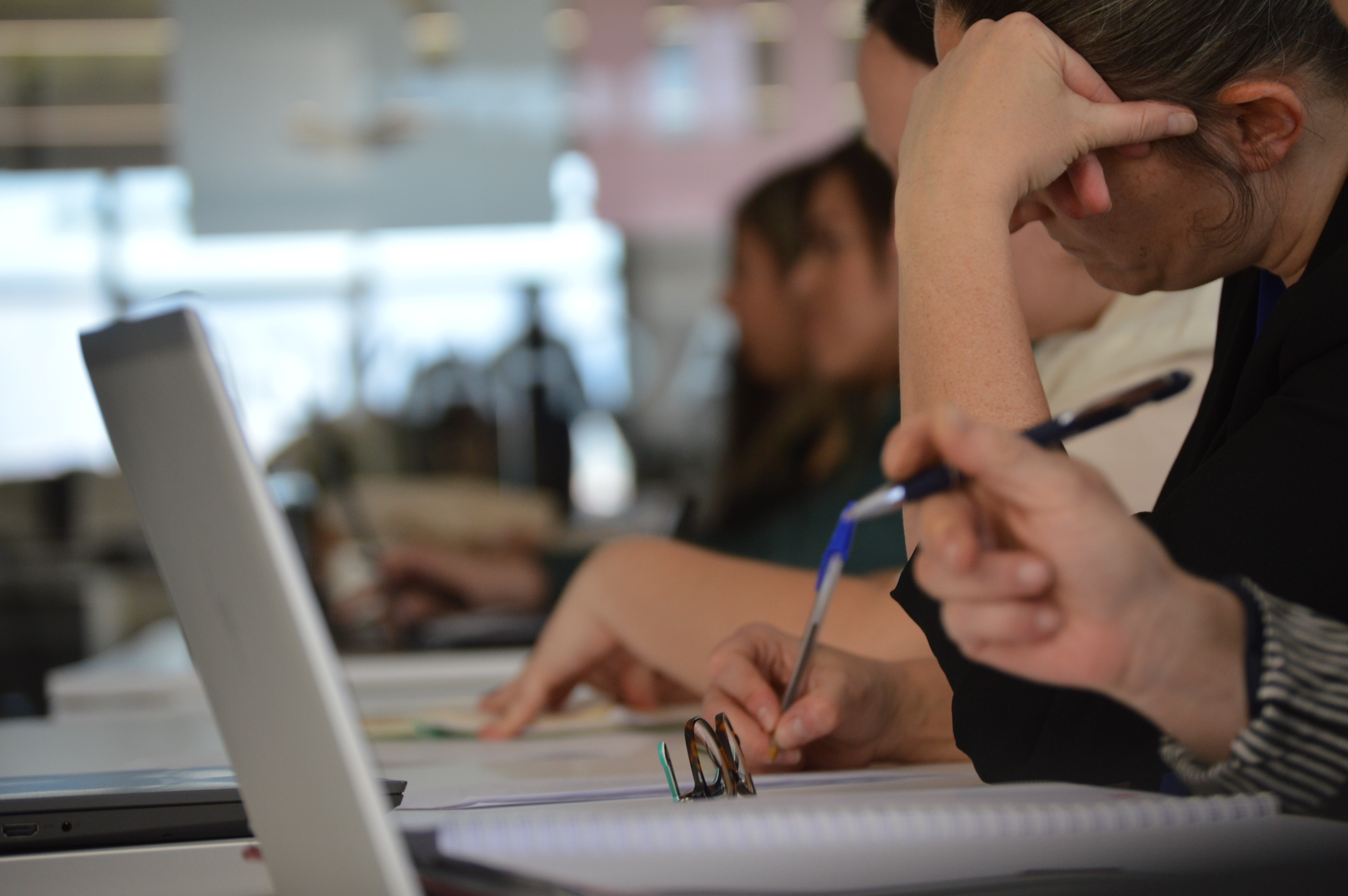 Equipo colaborando frente a un portátil compartido